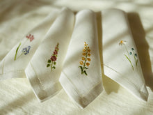 Ielādēt attēlu galerijas skatītājā, white linen napkins with machine‑embroidered meadow wildflowers motifs and hemstitched edges
