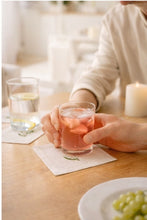 Load image into Gallery viewer, Bring quiet, botanical elegance to your table with these linen coasters embroidered with lily of the valley. Made from natural European linen, they protect surfaces beautifully while adding a refined spring-floral detail. Perfect for coffee moments, hosting, and thoughtful gifting.