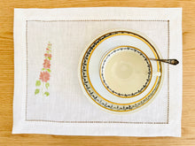 Ielādēt attēlu galerijas skatītājā, white linen placemats with machine‑embroidered meadow wildflowers motifs and hemstitched edges - perfect eco table linens for botanical dining; hostess gifts.