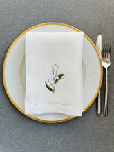 Ielādēt attēlu galerijas skatītājā, A thoughtful and elegant gift for someone who loves beautifully set tables and meaningful floral details.
Add soft floral elegance to your table with these off-white linen dinner napkins, delicately embroidered with lily of the valley flowers in one corner. Known for their symbolism of purity, renewal, and quiet beauty, lily of the valley motifs bring a gentle, sophisticated accent to both everyday meals and special occasions.