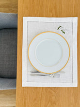 Load image into Gallery viewer, Bring quiet, botanical elegance to your table with these linen place mats embroidered with lily of the valley. Made from natural European linen, they protect surfaces beautifully while adding a refined spring-floral detail. Perfect for coffee moments, hosting, and thoughtful gifting.