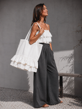 Load image into Gallery viewer, White linen tote bag with romantic ruffle detail, handmade linen shopper bag hanging on a grey wooden wall