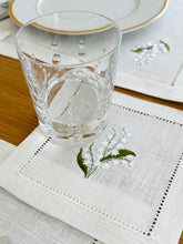 Load image into Gallery viewer, linen coasters embroidered with lily of the valley. Made from natural European linen, they protect surfaces beautifully while adding a refined spring-floral detail. Perfect for coffee moments, hosting, and thoughtful gifting.
