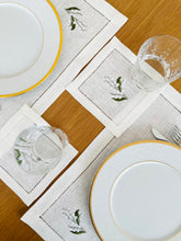 Load image into Gallery viewer, linen coasters embroidered with lily of the valley. Made from natural European linen, they protect surfaces beautifully while adding a refined spring-floral detail. Perfect for coffee moments, hosting, and thoughtful gifting.