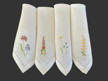 Ielādēt attēlu galerijas skatītājā, white linen napkins with machine‑embroidered meadow wildflowers motifs and hemstitched edges

