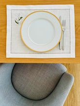 Load image into Gallery viewer, Bring quiet, botanical elegance to your table with these linen place mats embroidered with lily of the valley. Made from natural European linen, they protect surfaces beautifully while adding a refined spring-floral detail. Perfect for coffee moments, hosting, and thoughtful gifting.

