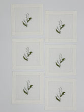 Load image into Gallery viewer, Bring quiet, botanical elegance to your table with these linen coasters embroidered with lily of the valley. Made from natural European linen, they protect surfaces beautifully while adding a refined spring-floral detail. Perfect for coffee moments, hosting, and thoughtful gifting.
