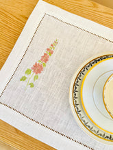 Ielādēt attēlu galerijas skatītājā, white linen placemats with machine‑embroidered meadow wildflowers motifs and hemstitched edges - perfect eco table linens for botanical dining; hostess gifts.
